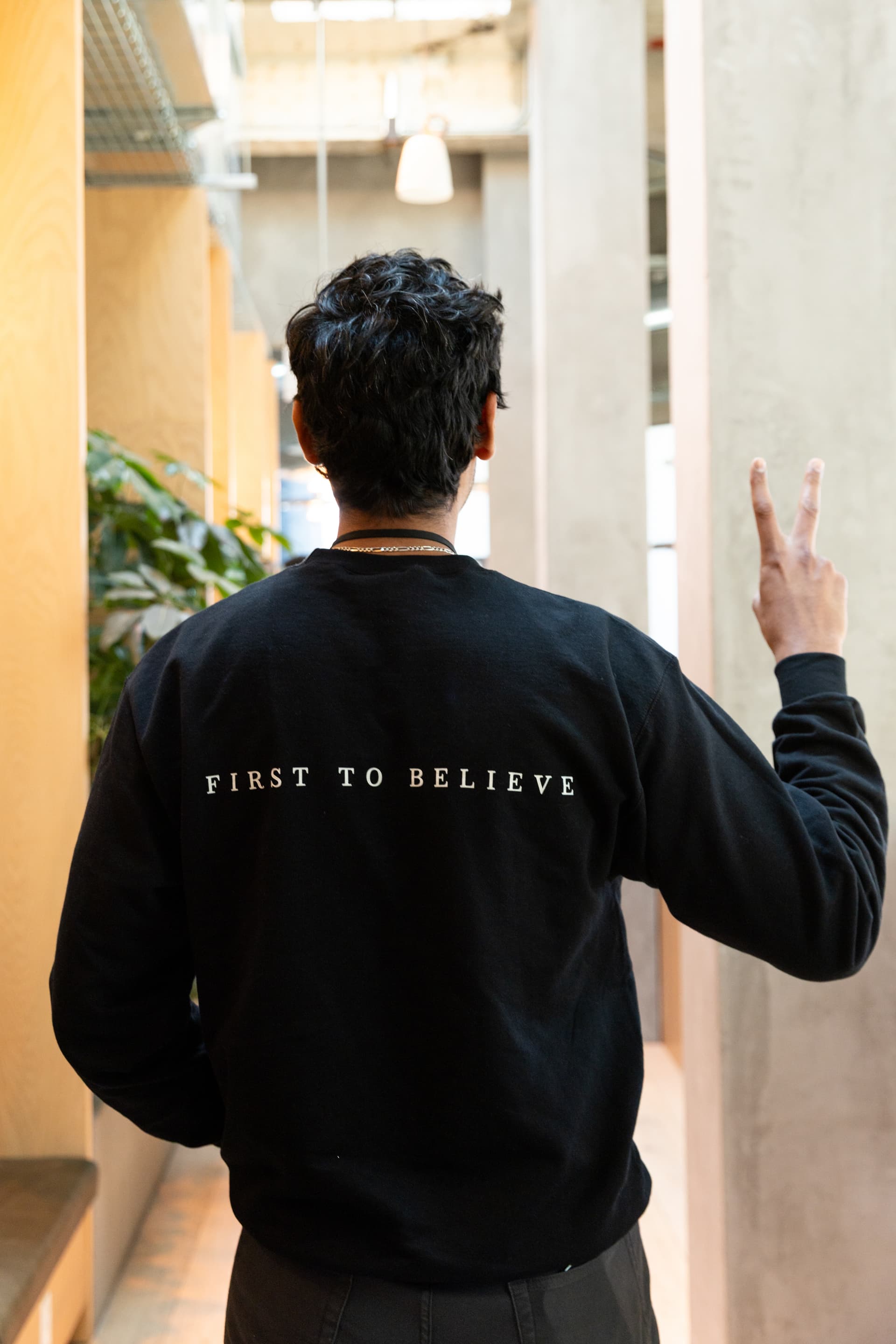 Founder walking forward in a First to Believe sweatshirt